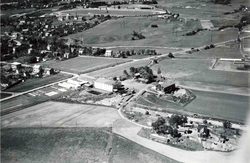 Vollebekk gård, luftfoto fra sørøst. Bjerkebanen i bakgrunnen. Foto 1949 Widerøe/Byantikvaren.
